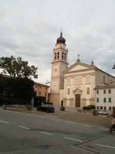 una chiesa con una torre dell'orologio in cima a un edificio di alloggio verona est S. Pietro a Lavagno