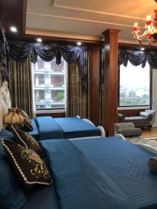 a bedroom with two blue beds and a window at Elisa Hotel in Ninh Binh