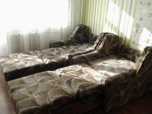 Сomfort&Servis Apartment on Mira of Yuzhny في يوجني: أريكة للجلوس في غرفة المعيشة بجوار نافذة