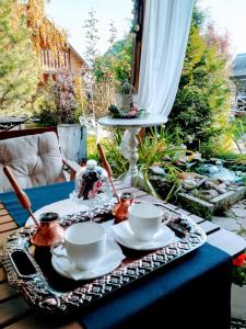 ジヴェエヴォにあるПансион Радонеж Дивеевоの茶碗2杯と円盤付きテーブル