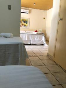 a room with two beds in a room with a tile floor at Pousada Canto do Boldró in Fernando de Noronha