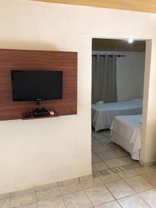 a room with a flat screen tv on a wall at Pousada Canto do Boldró in Fernando de Noronha +71 photos