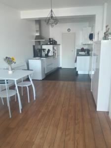 een keuken en een woonkamer met een witte tafel en een eetkamer bij appartement vue mer in Audierne