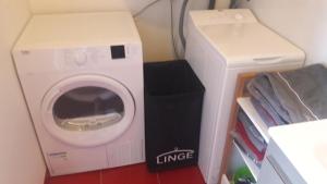 a washer and a dryer in a room with aigeriger at appartement vue mer in Audierne +3 photos