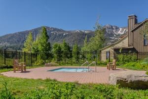 een zwembad met een glijbaan en twee banken in een tuin bij Lodges 1132 in Mammoth Lakes