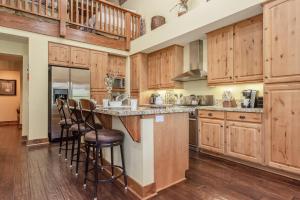 uma grande cozinha com armários de madeira e bancos de bar em Lodges 1132 em Mammoth Lakes