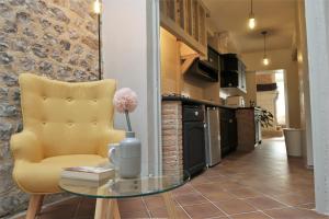sala de estar con mesa de cristal y silla amarilla en La Suite, en Saint-Valéry-en-Caux
