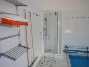 a bathroom with a shower and a shelf with towels at Villa Holiday in Karlovy Vary