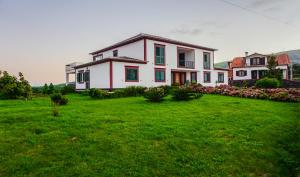 a large white house with a green yard at Moradia da Graça Guesthouse in Praia da Vitória