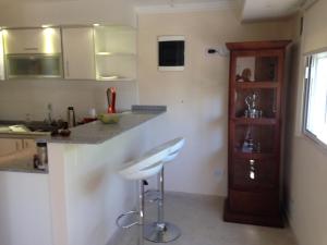 una cucina con bancone e un bar con sgabelli di Confortable departamento entero a Belén de Escobar