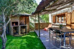 un patio al aire libre con mesa y chimenea en Cal Gineró, en Vall de Castellbò