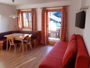 a living room with a red couch and a table at Haus Weitgasser in Flachau