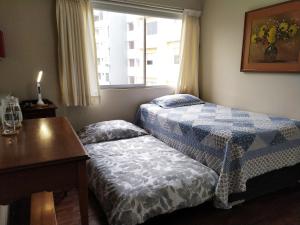 Habitación con 2 camas, mesa y ventana en Susana´s Private Room with Breakfast - Miraflores, en Lima