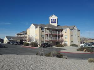 ein großes Apartmenthaus mit einem Schild darüber in der Unterkunft InTown Suites Extended Stay Albuquerque NM in Albuquerque