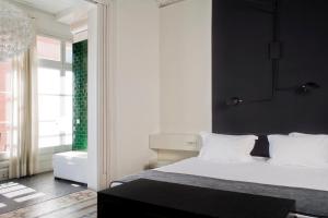 a bedroom with a white bed and a black wall at Praktik Rambla in Barcelona