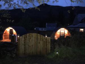 a night view of two circular houses with lights at Strathyre Camping Pods in Strathyre