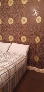 a bedroom with a bed with a floral wallpaper at Hotel Avansi in Blackpool
