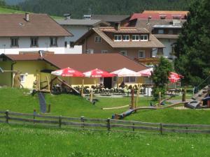 ein Resort mit Tischen und Sonnenschirmen auf einem Feld in der Unterkunft Ferienhaus Stupp in Gries im Sellrain