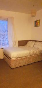 a bed sitting in a bedroom with a window at Hotel Avansi in Blackpool