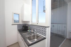 een keuken met een wastafel en een glazen douche bij Alleria in Ravello