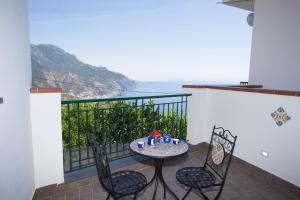 een tafel en stoelen op een balkon met uitzicht bij Alleria in Ravello