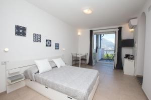 een witte slaapkamer met een bed en een balkon bij Alleria in Ravello