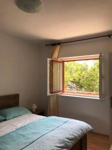 a bedroom with a bed and a window at Family friendly holiday home "Ana" in Šibenik