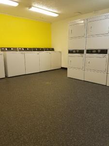 an empty room with white lockers and a yellow wall at InTown Suites Extended Stay Houston TX - West Oak in Houston