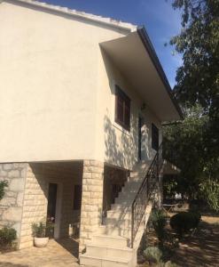 a white house with stairs in front of it at Family friendly holiday home "Ana" in Šibenik