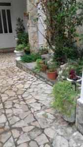 a stone patio with potted plants and a building at Apartment Gabric in Rab