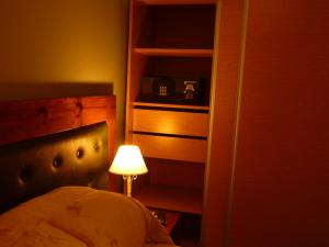 a bedroom with a bed and a lamp next to a book shelf at Garden House Hotel in Río Cuarto