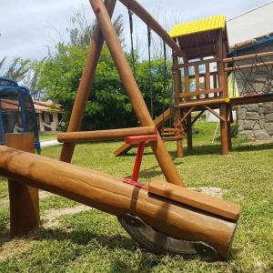 a playground with a large wooden swingothal at Pousada Viva Mar in Saquarema
