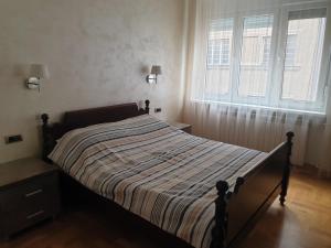 ein Bett in einem Schlafzimmer mit einem großen Fenster in der Unterkunft Metropol Lux apartment Belgrade Vracar in Belgrad