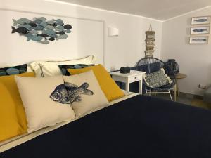 um quarto com uma cama com almofadas amarelas e brancas em IL CUCCO B&B em Ginosa Marina