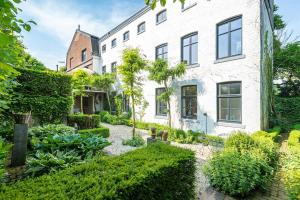 グルペンにあるDe Auw Sjoekelaatfabriekの白い建物前の庭