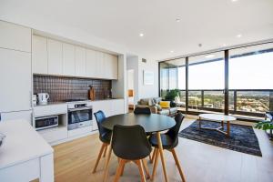 a kitchen and living room with a table and chairs at Swainson at Vue in Adelaide