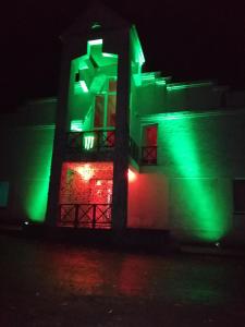 a building with green lights on it at night at Poilsio namai Šaltinelis in Plateliai