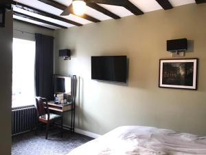 sypialnia z łóżkiem i telewizorem na ścianie w obiekcie Bay horse hotel w mieście Selby