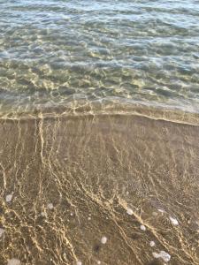 um close da areia e da água na praia em IL CUCCO B&B em Ginosa Marina