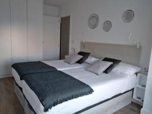 a large white bed in a room with two pillows at Morriña in Ourense