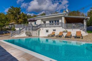 a house with a swimming pool in front of a house at Villa Manta Crikvenica in Crikvenica