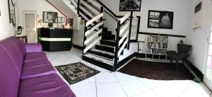 a living room with a purple couch and stairs at Urussanga Hotel in Urussanga