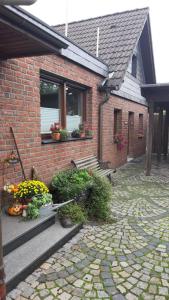 a brick house with flowers and plants in front of it at Standardzimmer nahe Messe und Airport in Düsseldorf