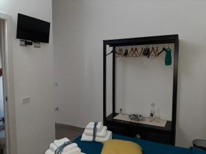 uno specchio in una stanza con asciugamani su un tavolo di Borgo Marinaro La Medusa Arbatax - camera matrimoniale con bagno privato a Àrbatax