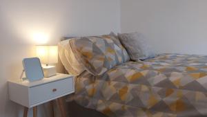 a bedroom with a bed and a night stand with a lamp at Parton Residence in Liverpool