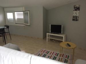 Televízia a/alebo spoločenská miestnosť v ubytovaní Apartamentos Susa