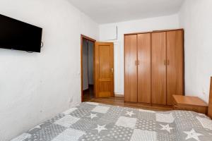 1 dormitorio con 1 cama y TV en la pared en Apartamento Benjamin Rodriguez, en Alicante
