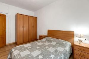1 dormitorio con 1 cama y armarios de madera en Apartamento Benjamin Rodriguez, en Alicante