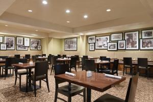 a dining room with tables and chairs and pictures on the walls at USC Hotel in Los Angeles