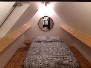 Un dormitorio con una cama y un espejo en la pared. en Villa Cocoon, en Saint-Jean-aux-Bois
